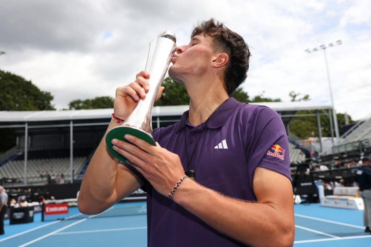 Czech Republic's Jakub Mensik kisses his trophy after victory against Argentina's Sebastian Baez in their men's singles final match at the ATP Auckland Classic tennis tournament in Auckland on January 17, 2026. Michael Bradley / AFP