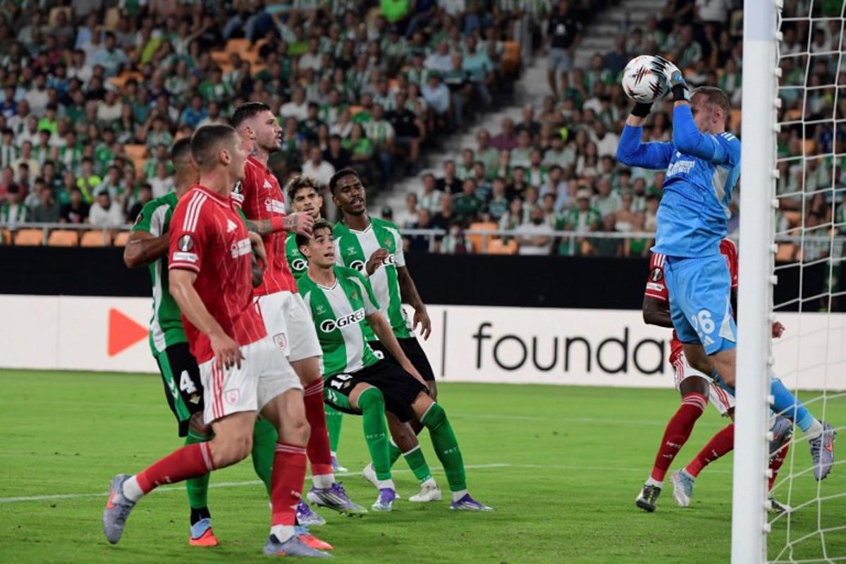 Nottingham Forest's Belgian goalkeeper #26 Matz Sels catches de ball during the UEFA Europa League 1st round day 1 football match between Real Betis and Nottingham Forest at the Benito Villamarin stadium in Seville on September 24, 2025. CRISTINA QUICLER / AFP