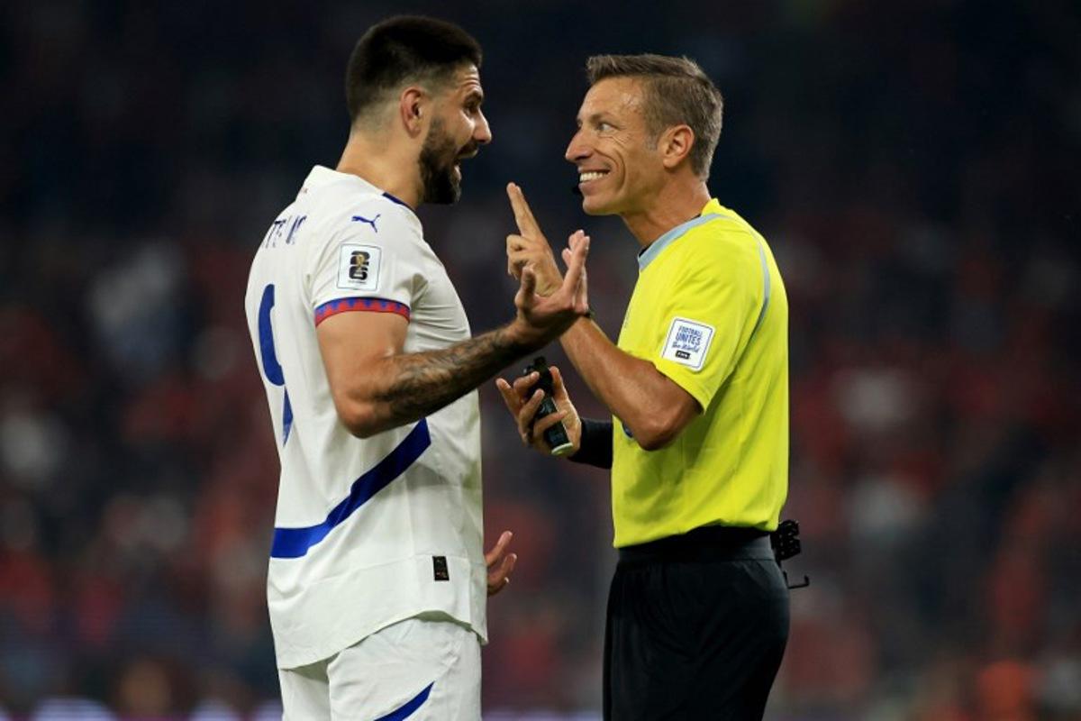 Serbia's forward #09 Aleksandar Mitrovic (L) talks to Italian referee Davide Massa during the 2026 World Cup qualifiers Europe zone, 1st round group K football match between Albania and Serbia at the Air Albania Stadium in Tirana on June 7, 2025. Adnan Beci / AFP