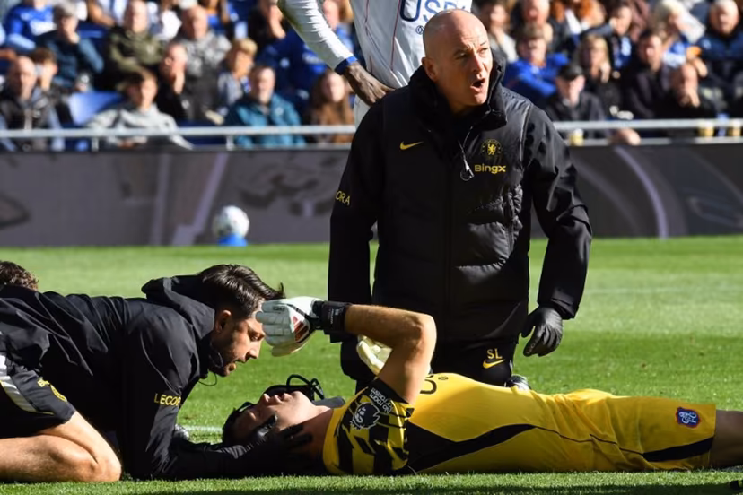 Chelsea's Argentinian goalkeeper #26 Emiliano Martinez is treated after picking up an injury during the English Premier League football match between Everton and Chelsea at Hill Dickinson Stadium in Liverpool, north west England on October 17, 2026. PETER POWELL / AFP