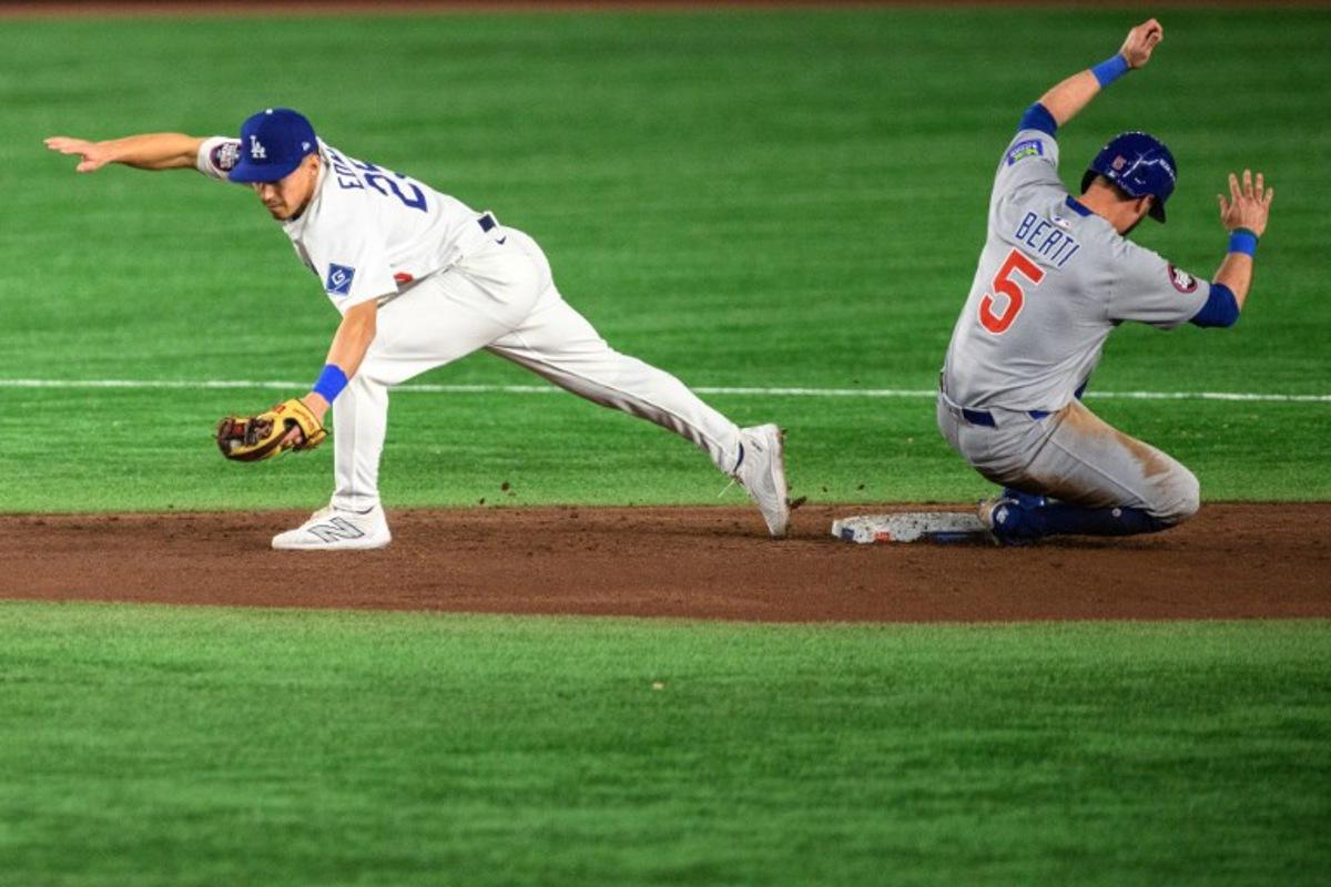 LA Dodgers' Tommy Edman (L) catches the ball as Chicago Cubs' Jon Berti slides to second base during the baseball game between the Los Angeles Dodgers and Chicago Cubs in the MLB Tokyo Series at the Tokyo Dome in Tokyo on March 19, 2025. Philip FONG / AFP