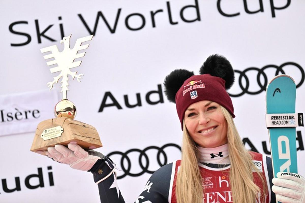 Third-placed US Lindsey Vonn holds her trophy as she celebrates on the podium of the women's Super G event during the FIS Alpine Ski World Cup 2025-2026, in Val d'Isere, southwestern France, on December 21, 2025. Jeff PACHOUD / AFP