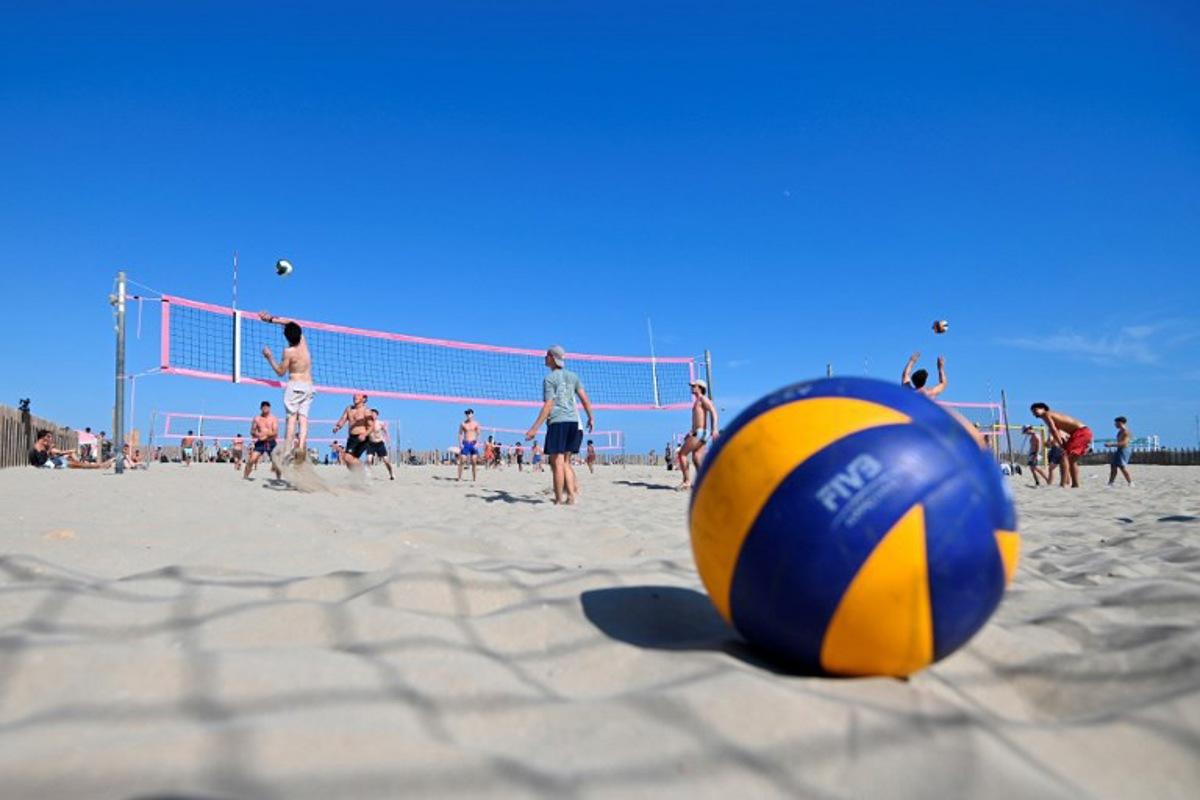 Beach-goers play beach volleyball on the beach in Carnon, southern France, on July 14, 2024. From Montpellier to Narbonne via Sète, from gymnasiums to beaches via the villages of the hinterland, French volleyball has shined for almost 100 years with a particular brilliance on the banks of the Mediterranean, far from Paris which hosts the Olympic Games. Sylvain THOMAS / AFP