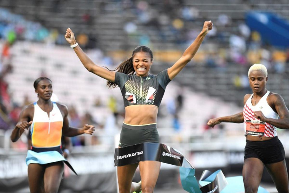 USA'S Gabrielle Thomas (C) of team New Balance crosses the finish line in first place, alognside Britain's Dina Asher Smith (L) and Bahrain's Salwa Eid Naser (R) in the women's 200 meter dash long sprint during the Grand Slam Track competition at the National Stadium in Kingston, Jamaica on April 4, 2025. Ricardo Makyn / AFP