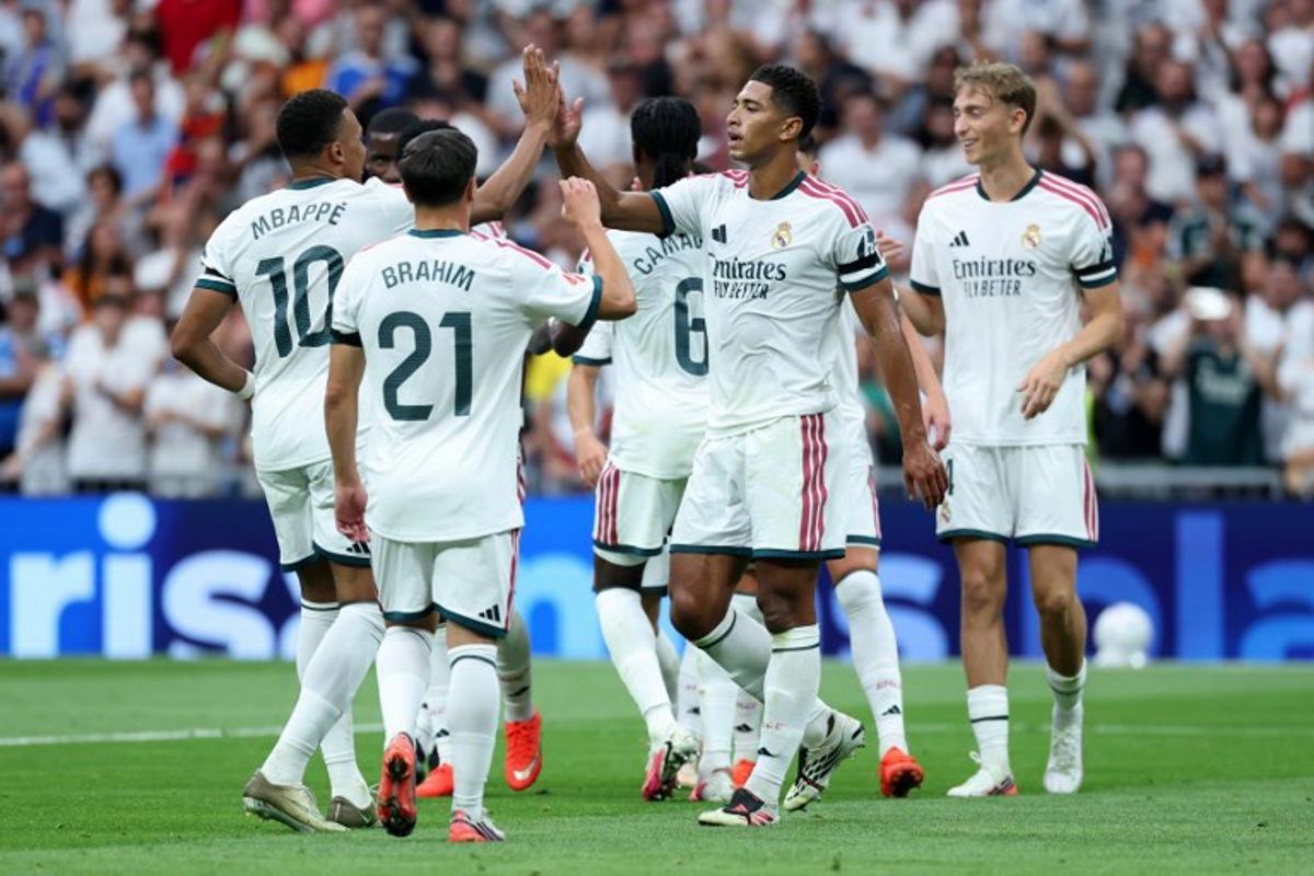 Real Madrid's English midfielder #05 Jude Bellingham celebrates with his teammates Real Madrid's French forward #10 Kylian Mbappe and Real Madrid's Moroccan forward #21 Brahim Diaz after scoring his team's second goal during the Spanish league football match between Real Madrid CF and Malaga CF at Santiago Bernabeu Stadium in Madrid on August 30, 2026. Thomas COEX / AFP