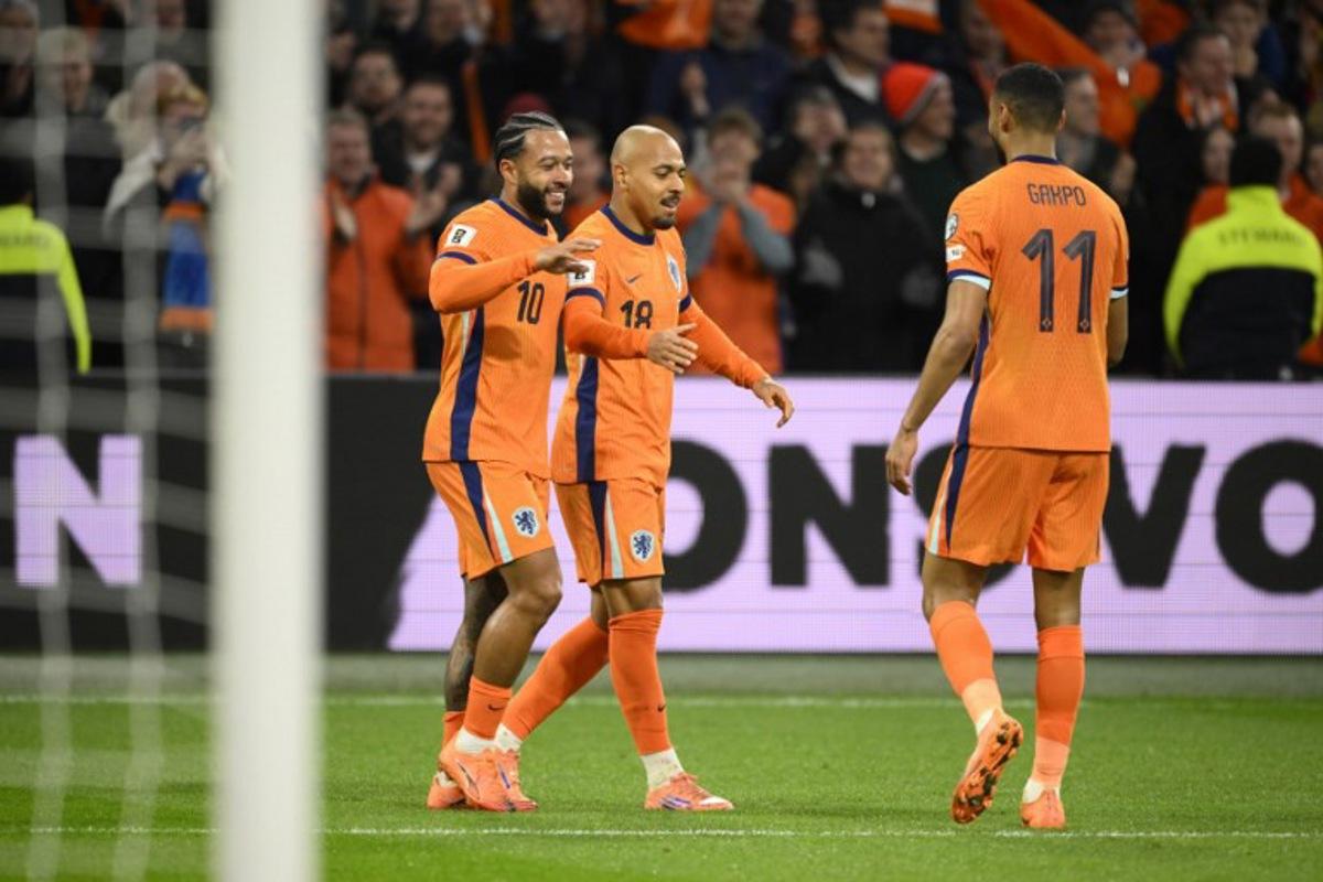 Netherlands' forward #18 Donyell Malen (C) celebrates after scroing the Netherlands fourth goal with Netherlands' forward #10 Memphis Depay (L) and Netherlands' forward #11 Cody Gakpo (R) during the FIFA World Cup 2026 Group G European qualification football match between the Netherlands and Lithuania at the Johan Cruijff Arena, in Amsterdam, on November 17, 2025. JOHN THYS / AFP