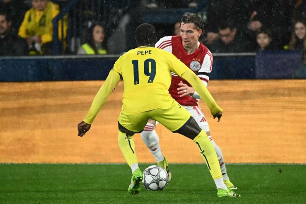 Villarreal's Ivorian forward #19 Nicolas Pepe and Ajax's Belgian forward #11 Mika Godts fight for the ball during the UEFA Champions League league phase day 7 football match between Villarreal CF and Ajax at La Ceramica Stadium in Vila-real on January 20, 2026. JOSE JORDAN / AFP