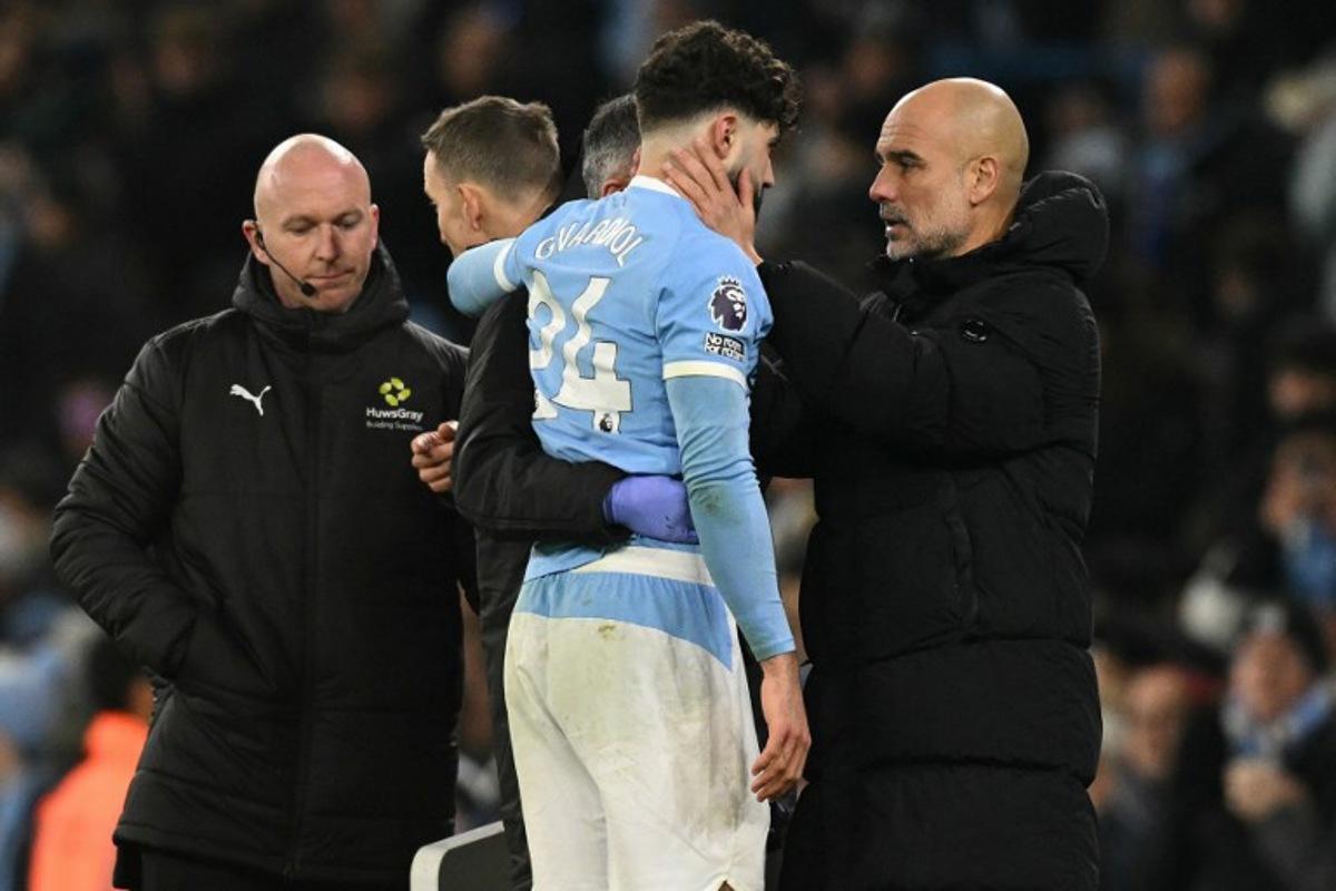 Manchester City's Croatian defender #24 Josko Gvardiol (C) speaks with Manchester City's Spanish manager Pep Guardiola after picking up an injury during the English Premier League football match between Manchester City and Chelsea at the Etihad Stadium in Manchester, north west England, on January 4, 2026. Oli SCARFF / AFP