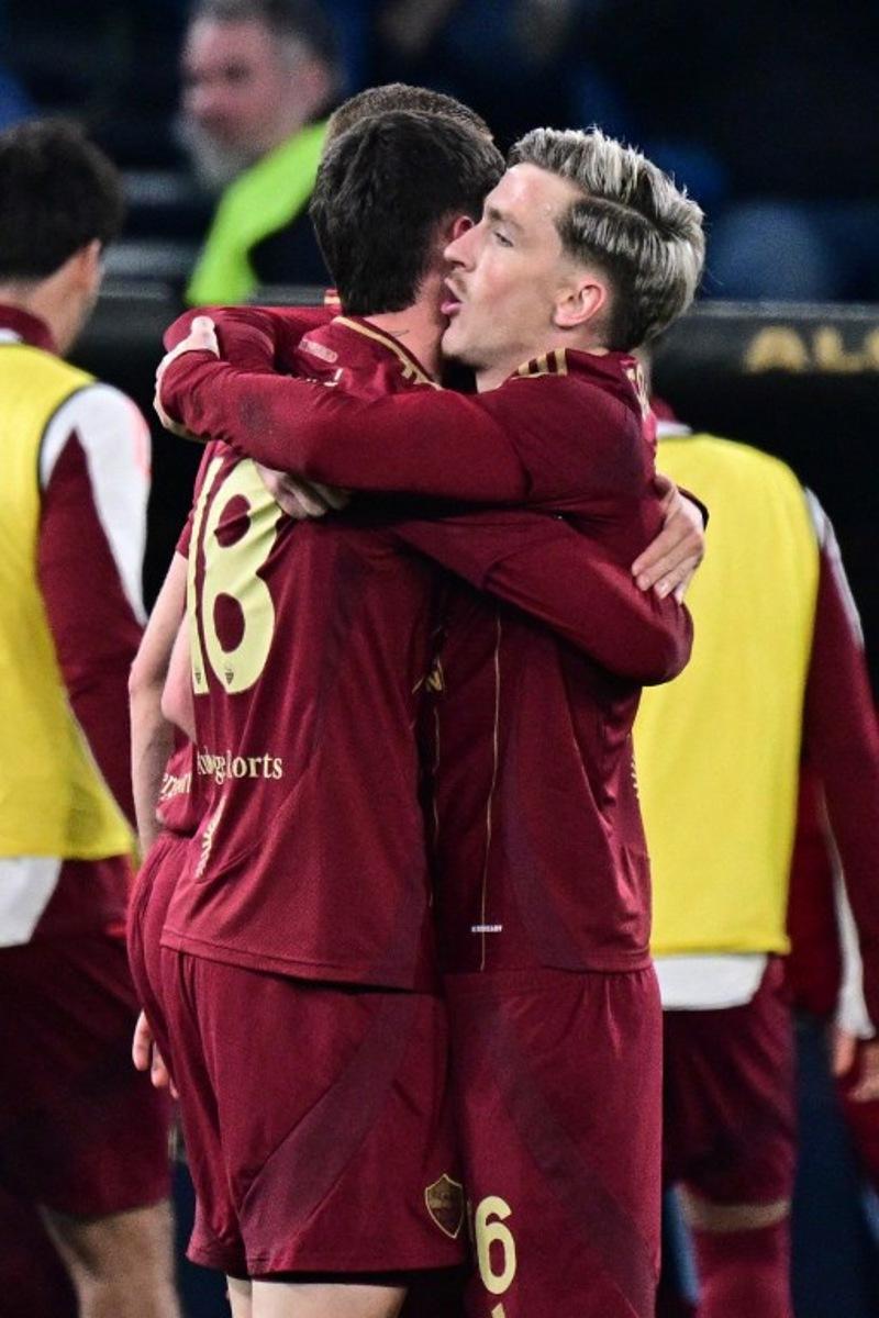 Roma's Argentine forward #18 Matias Soule celebrates with teammate Roma's Belgian forward #56 Alexis Saelemaekers (R) after scoring his team's first goal during the Italian Serie A football match between Lazio and Roma at the Olympic Stadium in Rome on April 13, 2025. Tiziana FABI / AFP