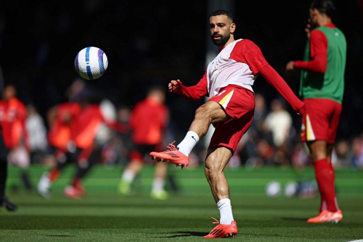 Liverpool's Egyptian striker #11 Mohamed Salah warms up ahead of the English Premier League football match between Fulham and Liverpool at Craven Cottage in London on April 6, 2025. HENRY NICHOLLS / AFP