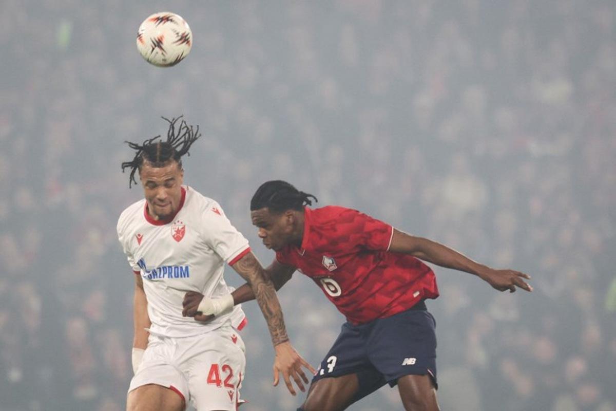 Crvena Zvezda Beograd's Dutch forward #42 Jay Enem (L) fights for the ball with Lille's Belgian defender #03 Nathan Ngoy (C) during the UEFA Europa League - knockout round play-off first leg - football match between LOSC Lille and FK Crvena Zvezda Beograd (Red Star Belgrade) at the Pierre Mauroy Stadium in Villeneuve d'Ascq, northern France, on February 19, 2026. Francois LO PRESTI / AFP
