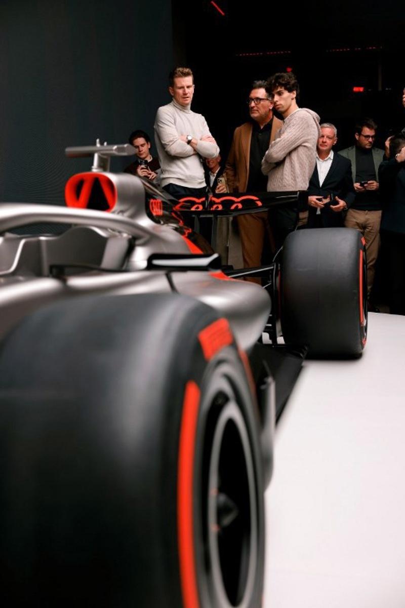 Massimo Frascella (C), Chief Creative Officer at AUDI AG, together with Kick Sauber's German driver Nico Hulkenberg (L) and Kick Sauber's Brazilian driver Gabriel Bortoleto (R) unveils the F1 car of the Audi F1 factory team set to compete in the Formula One starting in the 2026 season in Munich, southern Germany on November 12, 2025. Alexandra BEIER / AFP