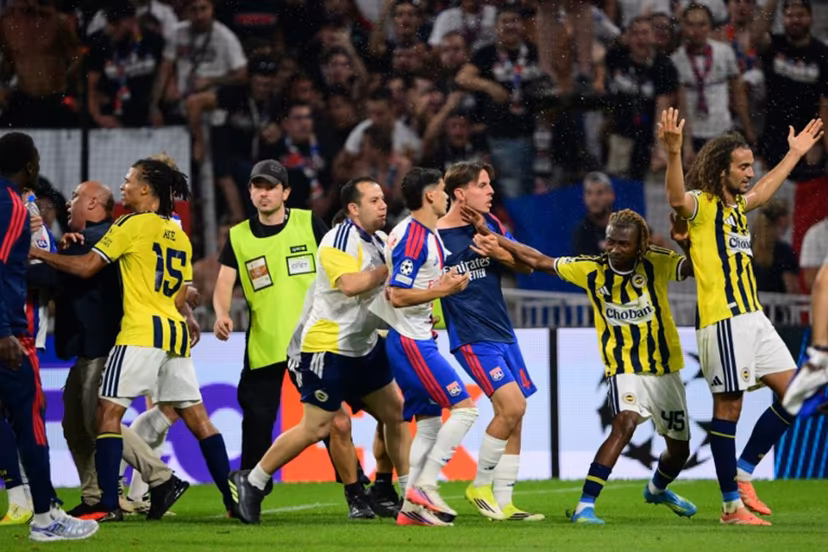 Fenerbahce's Malian forward #45 Nene Dorgeles (2R) tried to seperate Fenerbahce's French midfielder #06 Matteo Guendouzi (R) and Lyon's players after the final whistle at the end of the UEFA Champions League qualifying playoff - second leg football match between Olympique Lyonnais (OL) and Fenerbahce SK at the Groupama Stadium in Decines-Charpieu, central-eastern France, on August 26, 2026. Olivier CHASSIGNOLE / AFP