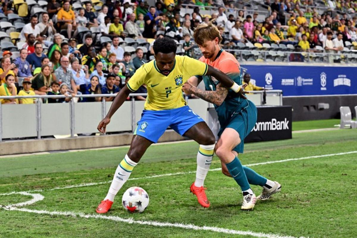 Brazil's Vinicius Junior (L) and Australia's Connor Metcalfe fight for the ball during the International friendly football match between Australia and Brazil at Queensland Country Bank Stadium in Townsville on September 25, 2026. SAEED KHAN / AFP