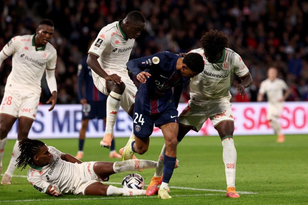 Nice's Algerian midfielder #06 Hicham Boudaoui (bottom) tackles Paris Saint-Germain's French midfielder #24 Senny Mayulu (C) during the French L1 football match between Paris Saint-Germain (PSG) and OGC Nice at the Parc des Princes stadium in Paris on November 1, 2025. FRANCK FIFE / AFP