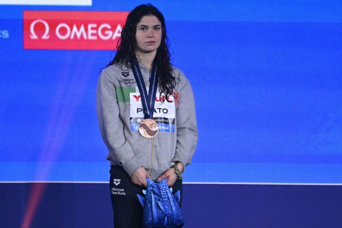 Italy's Benedetta Pilato poses with her bronze medal on the podium of the women's 50m breaststroke swimming event during the 2024 World Aquatics Championships at Aspire Dome in Doha on February 18, 2024. Oli SCARFF / AFP