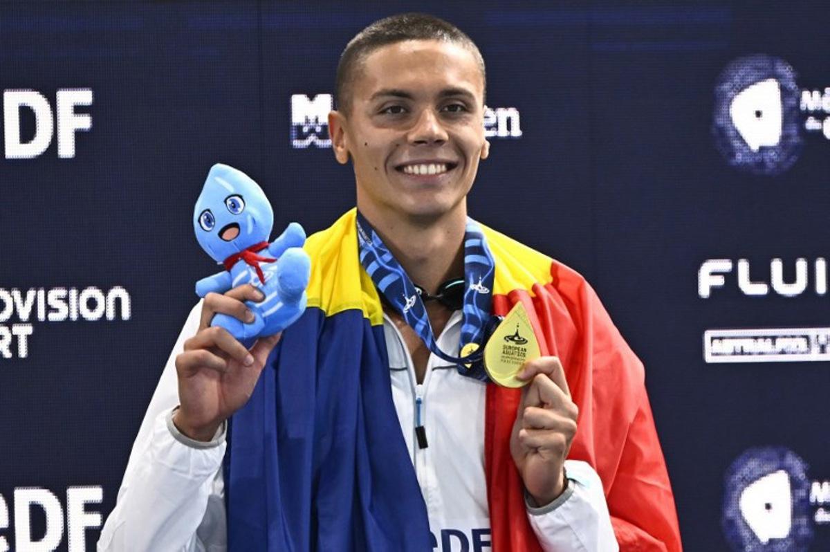 Romania's David Popovici poses with his gold medal on the podium of the men's 100m freestyle swimming event during the LEN European Aquatics Championships at the Olympic Aquatic Centre in Saint-Denis, northern suburbs of Paris, on August 12, 2026. JULIEN DE ROSA / AFP