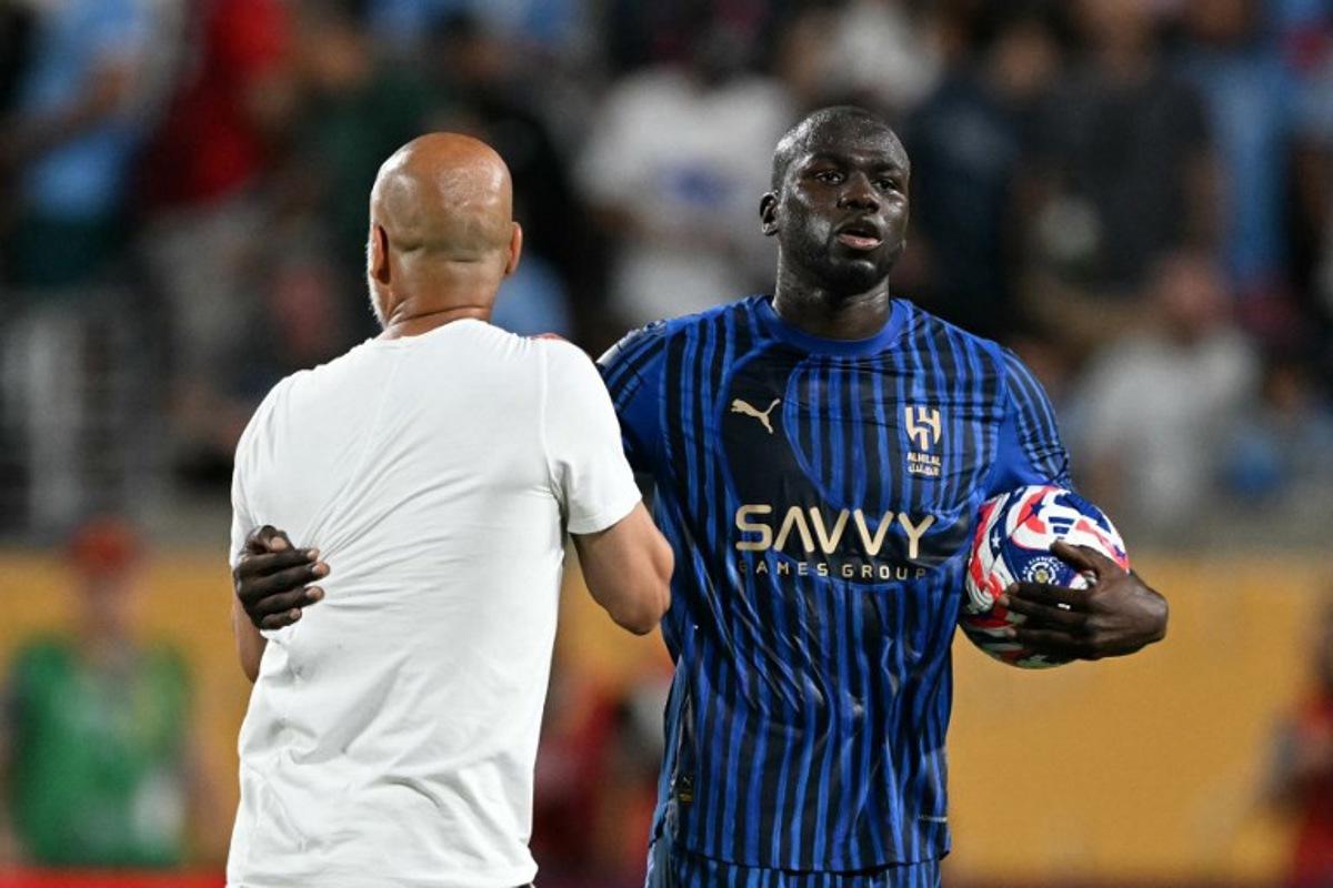 Al Hilal's Senegalese defender #03 Kalidou Koulibaly grabs Manchester City's Spanish head coach Pep Guardiola during the FIFA Club World Cup 2025 round of 16 football match between England's Manchester City and Saudi's Al-Hilal at the Camping World stadium in Orlando on June 30, 2025. PATRICIA DE MELO MOREIRA / AFP