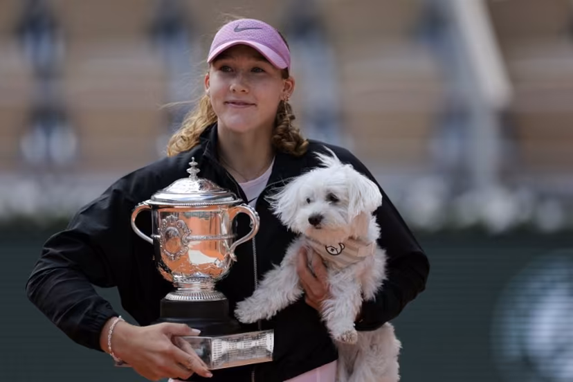 Russia's Mirra Andreeva poses with the Coupe Suzanne Lenglen (Suzanne Lenglen Trophy) and her dog after winning the French Open tennis tournament women's singles final match against Poland's Maja Chwalinska on day 14 of the French Open tennis tournament on Court Philippe-Chatrier at the Roland-Garros Complex in Paris on June 6, 2026. Thomas SAMSON / AFP