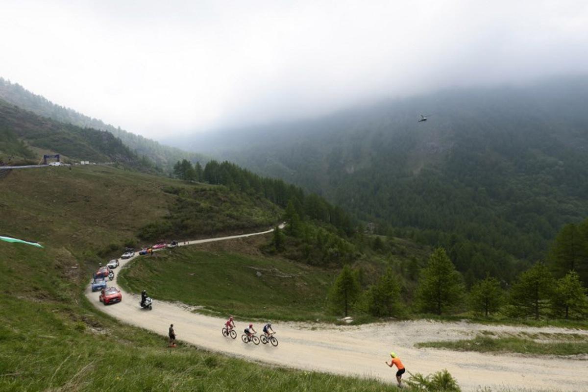 Spectators watch as riders cycle on the ascent of the Colle Delle Finestre during the 20th stage of the 108th Giro d'Italia cycling race 205kms from Verres to Sestriere on May 31, 2025. Luca Bettini / AFP