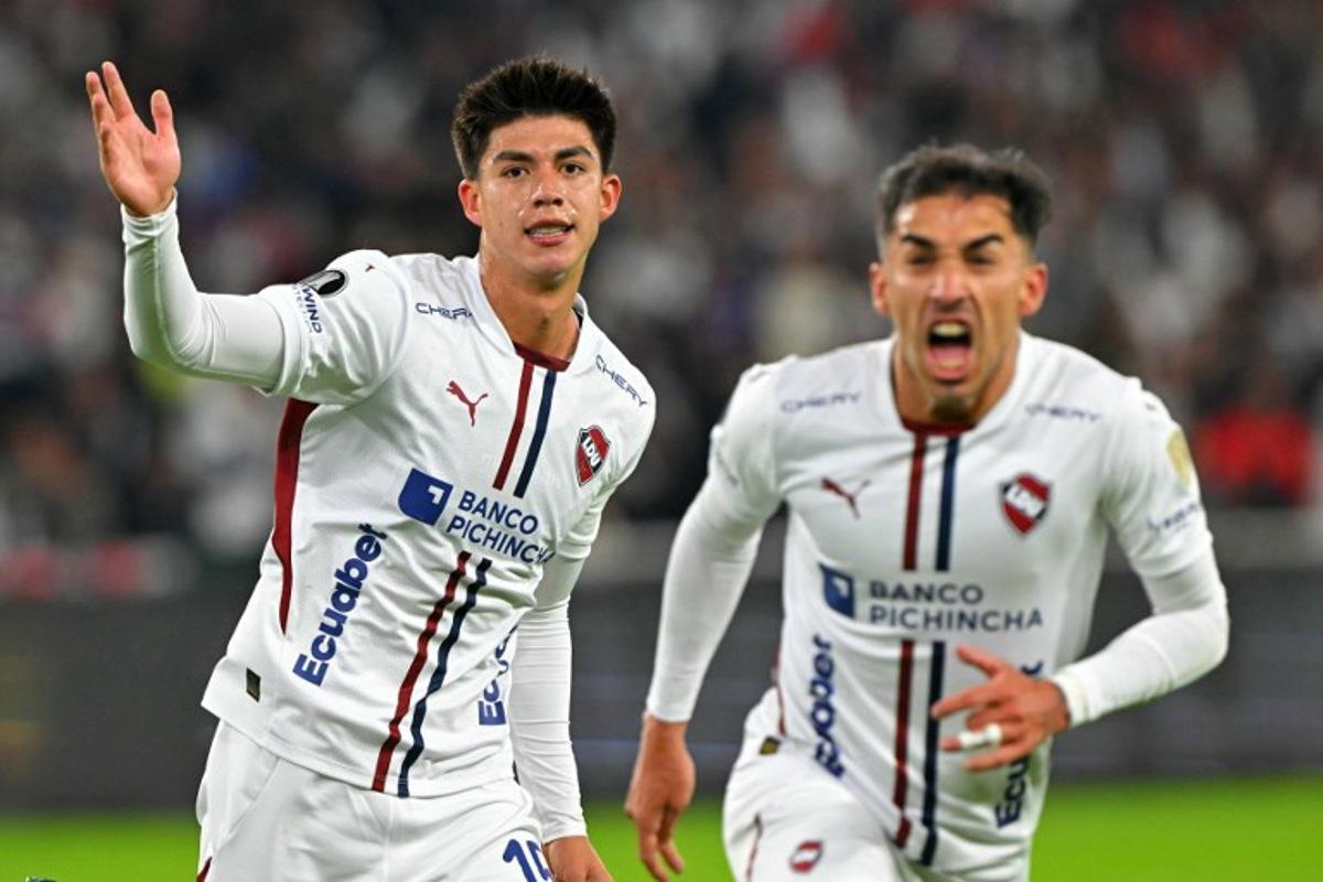 Liga de Quito's Bolivian midfielder #15 Gabriel Villamil (L) celebrates with a teammate scoring his team's first goal during the Copa Libertadores semifinal first leg football match between Ecuador's Liga de Quito and Brazil's Palmeiras at the Rodrigo Paz Delgado stadium in Quito on October 23, 2025. Rodrigo BUENDIA / AFP