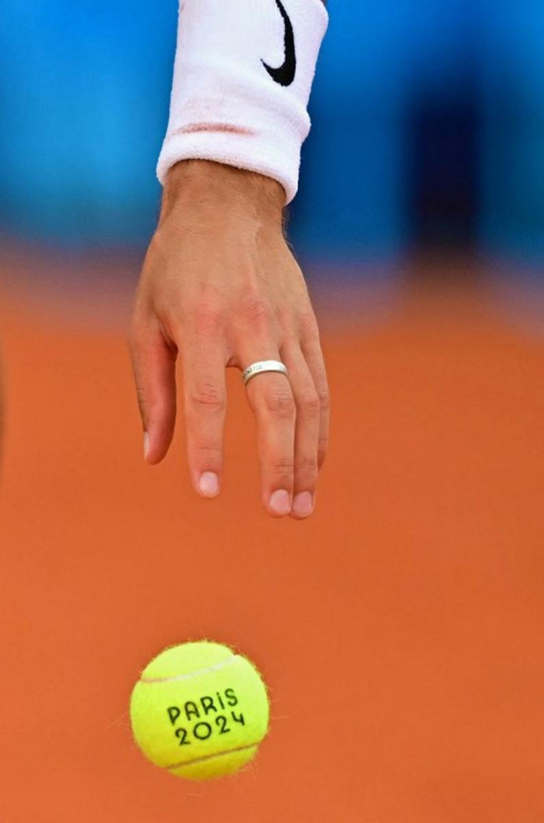 Italy's Lorenzo Musetti prepares to serve while playing France's Gael Monfils during their men's singles first round tennis match on Court Suzanne-Lenglen at the Roland-Garros Stadium at the Paris 2024 Olympic Games, in Paris on July 28, 2024. Martin BERNETTI / AFP