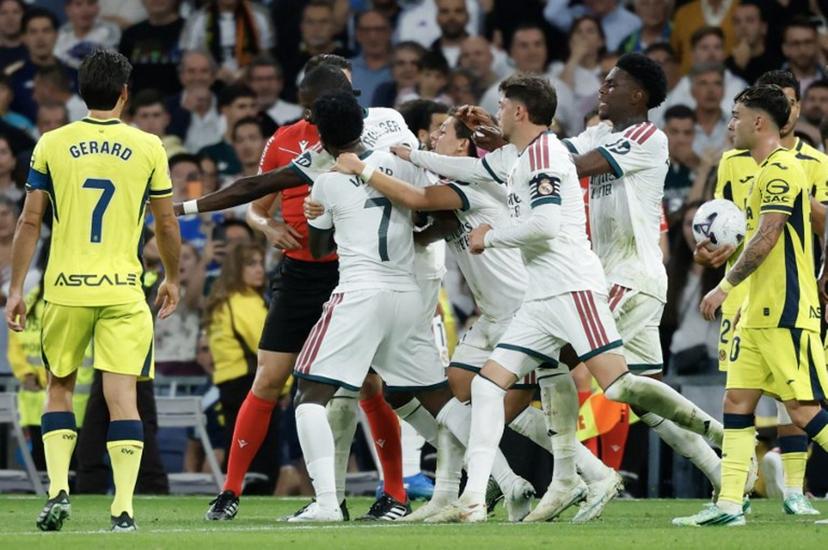 Real Madrid's Brazilian forward #07 Vinicius Junior (C) is restrained by teammates as he argues with referee Isidro Escuderos after receiving a red card during the Spanish league football match between Real Madrid CF and Villarreal CF at the Santiago Bernabeu Stadium in Madrid on October 10, 2026. Oscar DEL POZO / AFP