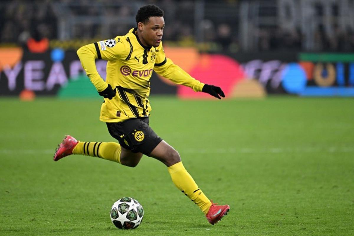 Dortmund's Belgian forward #16 Julien Duranville runs with the ball during the UEFA Champions League second-leg knockout round play-off football match BVB Borussia Dortmund vs Sporting CP at the Signal Iduna stadium in Dortmund, western Germany, on February 19, 2025. UWE KRAFT / AFP