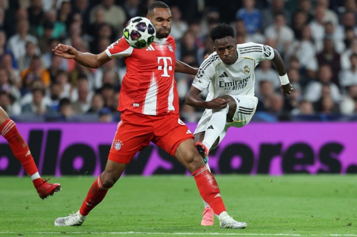 Real Madrid's Brazilian forward #07 Vinicius Junior (R) kicks past Bayern Munich's German defender #04 Jonathan Tah during the UEFA Champions League quarter final first leg football match between Real Madrid CF and FC Bayern Munich at Santiago Bernabeu Stadium in Madrid on April 7, 2026. Thomas COEX / AFP