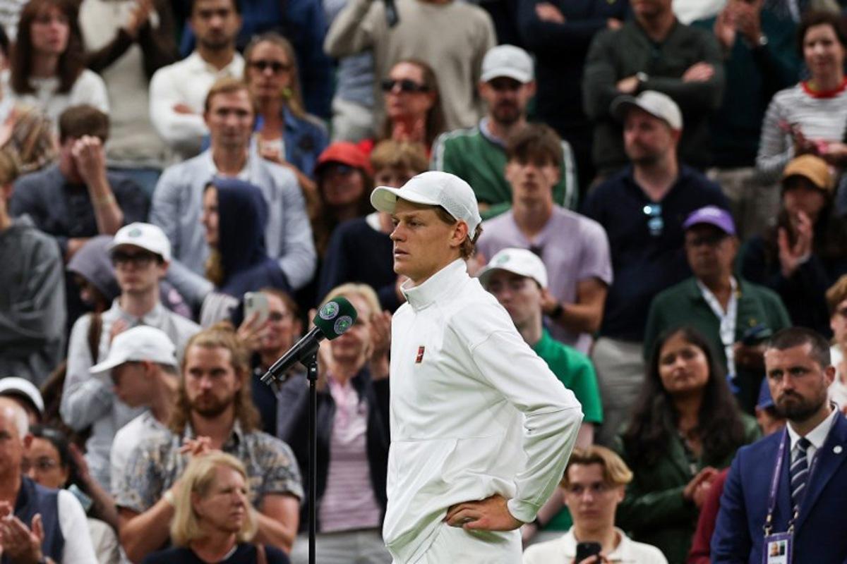 Italy's Jannik Sinner addresses the crowd after winning following the withdrew of Bulgaria's Grigor Dimitrov due to injury at the end of their men's singles fourth round tennis match on the eighth day of the 2025 Wimbledon Championships at The All England Lawn Tennis and Croquet Club in Wimbledon, southwest London, on July 7, 2025. Adrian Dennis / AFP