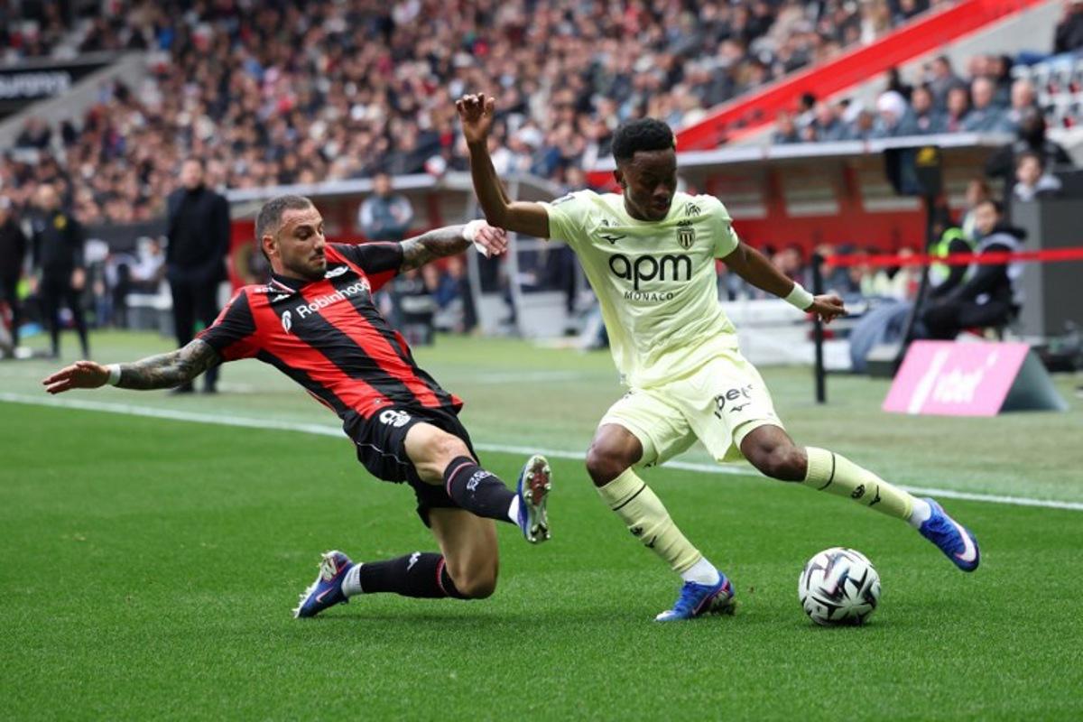 Nice's French defender #92 Jonathan Clauss (L) fights for the ball with Monaco's Simon Adingra (R) during the French L1 football match between OGC Nice and AS Monaco at the Allianz Riviera Stadium in Nice, south-eastern France on February 8, 2026. Valery HACHE / AFP