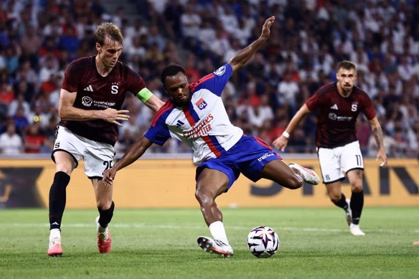 Sparta Praha's Danish defender #25 Asger Sorensen (L) and Lyon's Belgian forward #17 Lois Openda (C) fight for the ball during the UEFA Champions League third qualifying round - second leg football match between Olympique Lyonnais (OL) and Sparta Prague at Groupama Stadium in Decines-Charpieu, central-eastern France on August 11, 2026. Alex MARTIN / AFP