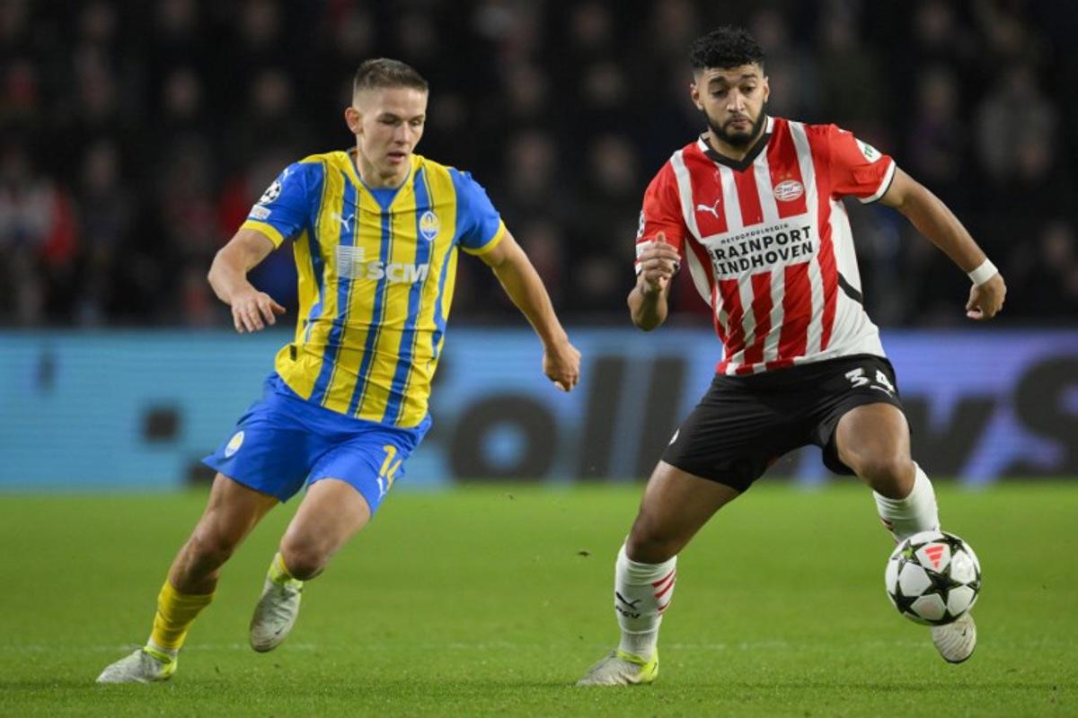 PSV Eindhoven's Moroccan midfielder #34 Ismael Saibari (R) fights for the ball with Shakhtar Donetsk's Ukrainian forward #14 Danylo Sikan during the UEFA Champions League, League phase - Matchday 5, football match between PSV Eindhoven and Shakhtar Donetsk at the The Philips Stadion in Eindhoven, on November 27, 2024. John THYS / AFP