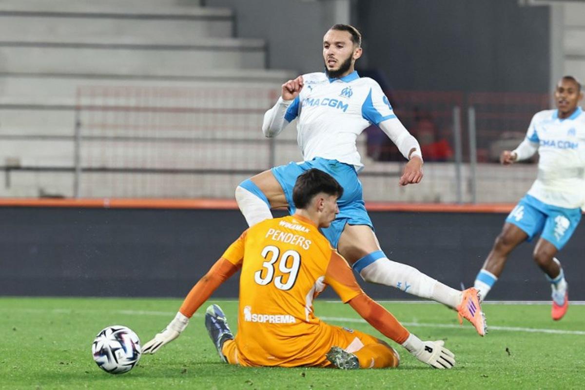 Strasbourg's Belgian goalkeeper #39 Mike Penders (DOWN) fights for the ball with Marseille's Algerian forward #09 Amine Gouiri during the French L1 football match between RC Strasbourg Alsace and Olympique de Marseille (OM) at the Stade de la Meinau in Strasbourg, eastern France, on September 26, 2025. Frederick FLORIN / AFP