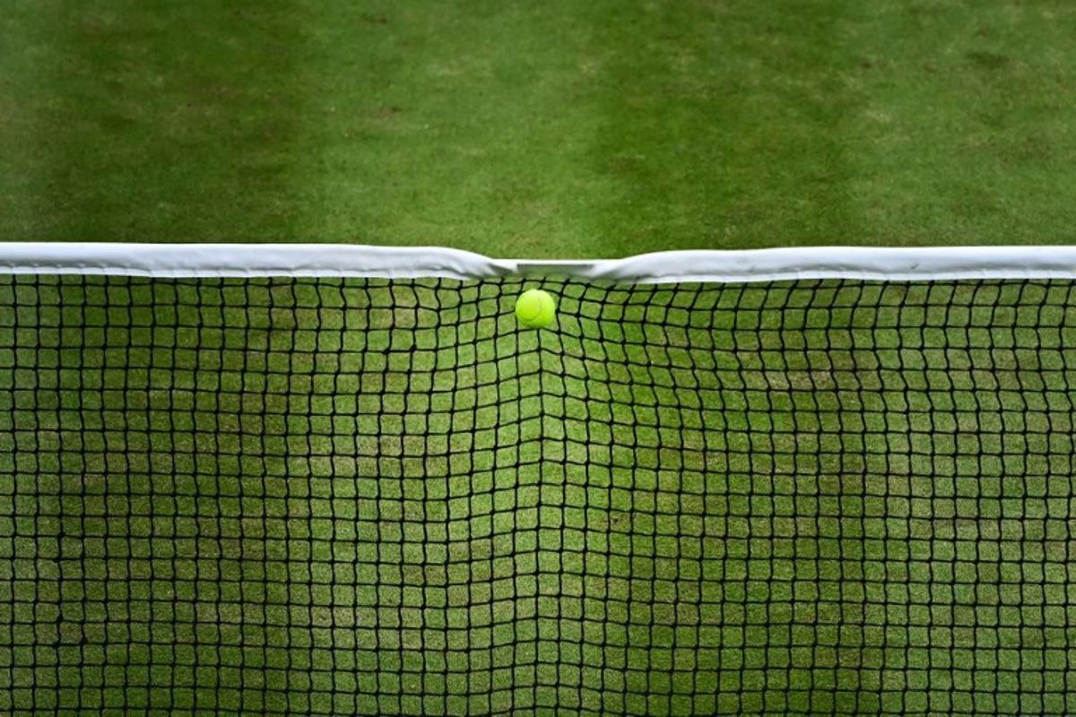 The ball served by Italy's Lorenzo Musetti hits the net during his men's singles quarter-finals tennis match against US player Taylor Fritz on the tenth day of the 2024 Wimbledon Championships at The All England Lawn Tennis and Croquet Club in Wimbledon, southwest London, on July 10, 2024. Ben Stansall / AFP