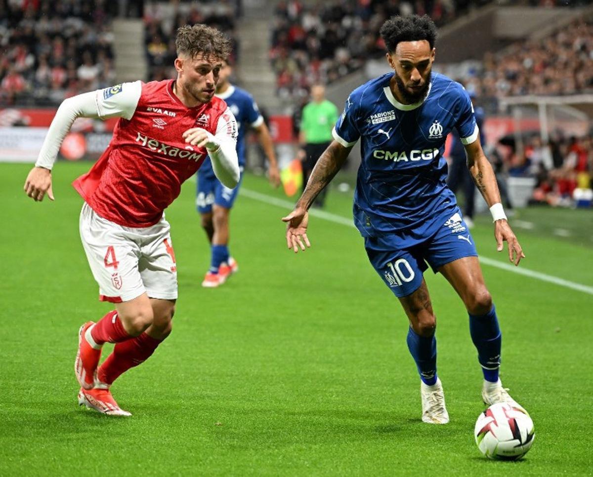 Reims' Belgian defender #04 Maxime Busi (L) fights for the ball with Marseille's French-Gabonese forward #10 Pierre-Emerick Aubameyang during the French L1 football match between Reims And Marseille on May 15, 2024 at Auguste-Delaune stadium in Reims. FRANCOIS NASCIMBENI / AFP