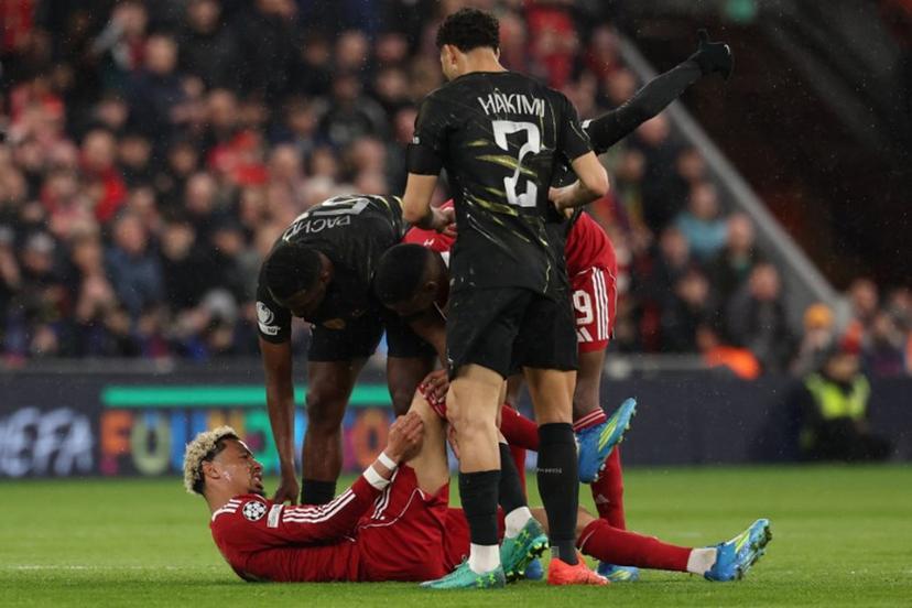 Players care for Liverpool's French striker #22 Hugo Ekitike who lies injured during the UEFA Champions League quarter final, second-leg football match between Liverpool and Paris Saint-Germain at Anfield in Liverpool, north west England on April 14, 2026. FRANCK FIFE / AFP