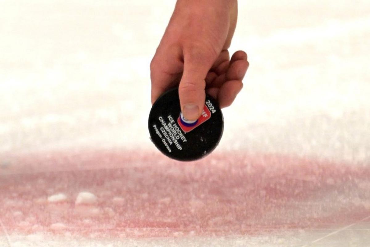 A referee lifts the puck during the IIHF Ice Hockey Men's World Championships match between USA and Germany in Ostrava, Czech Republic on May 11, 2024. Joe Klamar / AFP