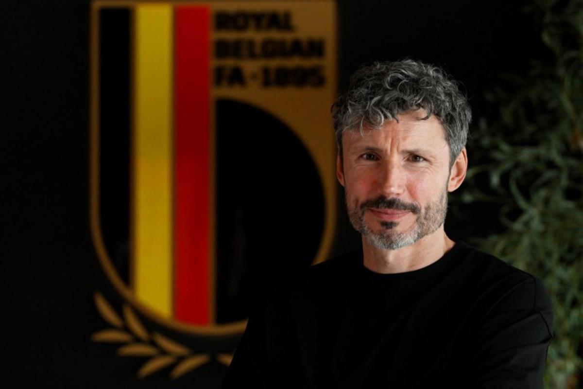 Netherland's Mark van Bommel poses in fornt of the Royal Belgian Football Association (RBFA) logo during a press conference for his presentation as new head coach of Belgium's national football team in Tubize on August 7, 2026. Netherlands' Mark van Bommel has been appointed Belgium's head coach, the Royal Belgian Football Association (RBFA) announced on on July 24, 2026, adding that the had signed a contract running until Euro 2028, to be held in the United Kingdom. JOHN THYS / AFP