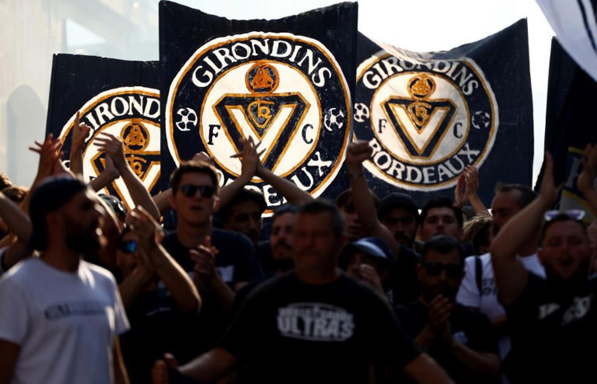 Supporters of French 'Nationale 2' fourth-tier club FC Girondins de Bordeaux wave the club's flags during a protest ahead of a hearing at the Direction Nationale du Controle de Gestion - DNGG, French football financial watchdog, following the six-time French champions' exclusion from national competitions, in Bordeaux, southwestern France July 19, 2026. Unless club officials secure a solution, Girondins de Bordeaux, also three-time French Cup winners, will be relegated to regional-level football following the DNCG's decision. ROMAIN PERROCHEAU / AFP