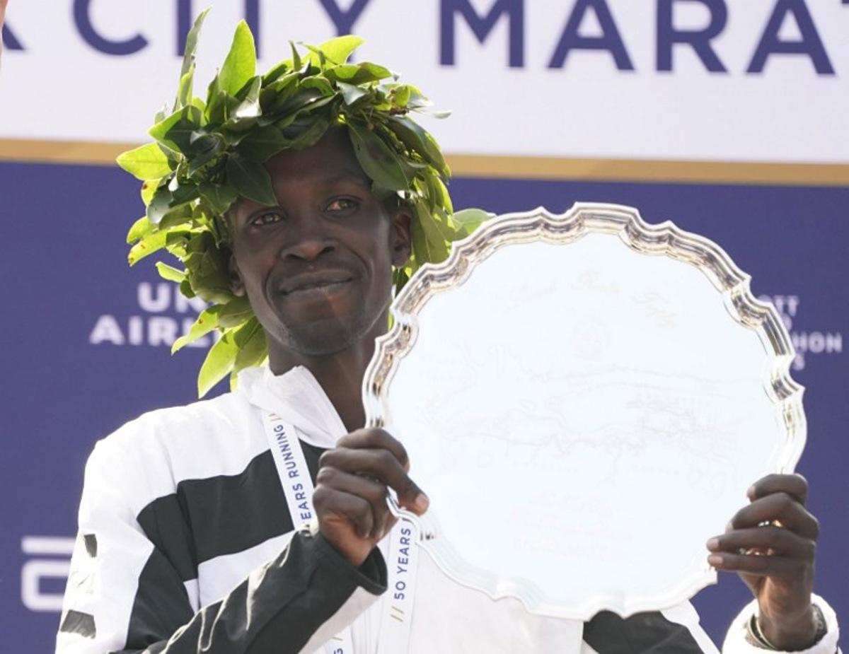 Men's division winner Albert Korir Kenya poses on the podium after the 2021 TCS New York City Marathon in New York on November 7, 2021. After a forced break in 2020, the New York City Marathon is back on for its 50th edition, and with it the countless opportunities to run it for charity, an industry that has become a staple, and hopes to take off again after the pandemic. TIMOTHY A. CLARY / AFP