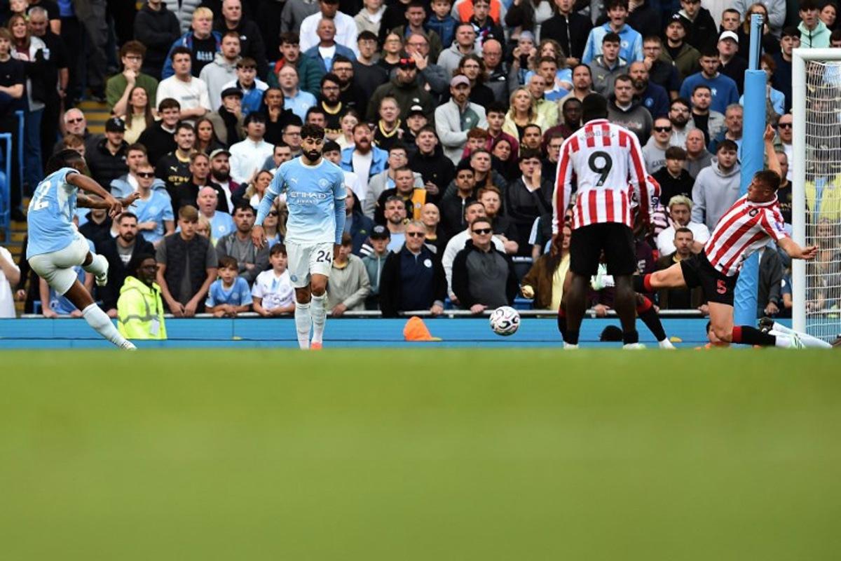 Manchester City's Ghanaian midfielder #42 Antoine Semenyo (L) shoots to score their third goal during the English Premier League football match between Manchester City and Sunderland at the Etihad Stadium in Manchester, north west England, on September 20, 2026. PETER POWELL / AFP