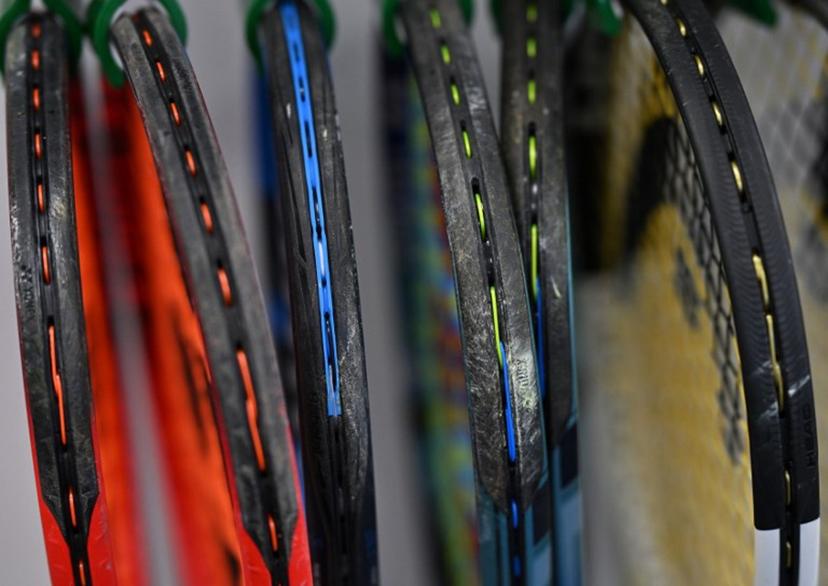 Players' freshly restrung tennis racquets hang awaiting collection in the racquet stringing department, before the start of play on the seventh day of the 2024 Wimbledon Championships at The All England Lawn Tennis and Croquet Club in Wimbledon, southwest London, on July 7, 2024. Glyn KIRK / AFP