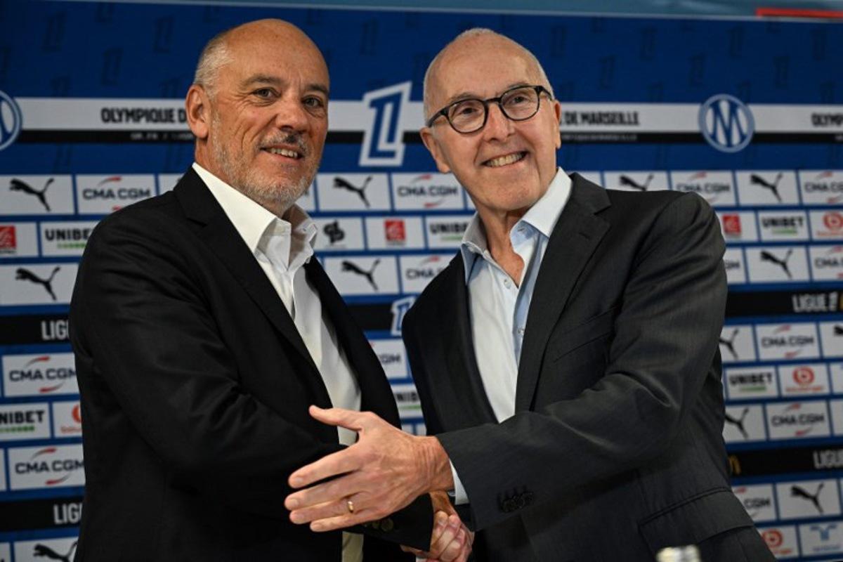 French fooball club Olympique de Marseille (OM) US owner Frank McCourt (R) shakes hand with the club's new president Stephane Richard (L) at the start of a press conference at the Velodrome Stadium in Marseille, southeastern France, on April 10, 2026. Gabriel BOUYS / AFP