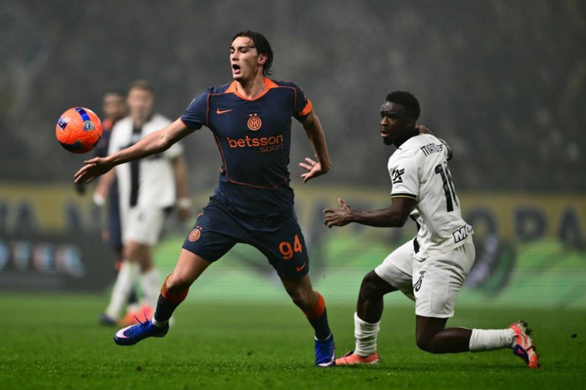Inter Milan's Italian forward #94 Pio Esposito fights for the ball with Parma's Belgian midfielder #16 Mandela Keita during the Italian Serie A football match between Parma and Inter Milan at the Ennio Tardini stadium in Parma on January 7, 2026. Marco BERTORELLO / AFP