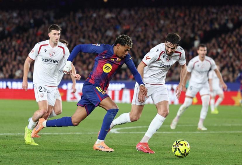 Barcelona's Spanish forward #10 Lamine Yamal fights for the ball with Osasuna's Spanish defender #24 Alejandro Catena as he attempts to score during the Spanish league football match between FC Barcelona and CA Osasuna at Camp Nou Stadium in Barcelona on December 13, 2025. Josep LAGO / AFP
