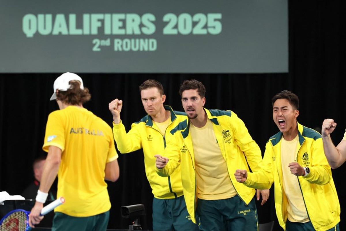 Australia's John Peers (2nd L), Thanasi Kokkinakis and Ricky Hijikata (R) react as they support team mate Alex de Minaur (L) during his match against Belgium's Zizou Bergs during the Davis Cup second-round qualifier tennis match at Ken Rosewall Arena in Sydney on September 14, 2025. DAVID GRAY / AFP