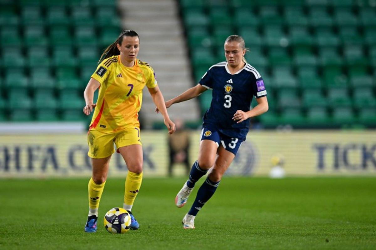 Belgium's forward #07 Hannah Eurlings runs with the ball from Scotland's Defender #03 Amy Muir during the Women's FIFA world cup league B, group 4, qualifier football match between Scotland and Belgium at Easter Road, in Edinburgh, Scotland, on April 14, 2026. ANDY BUCHANAN / AFP