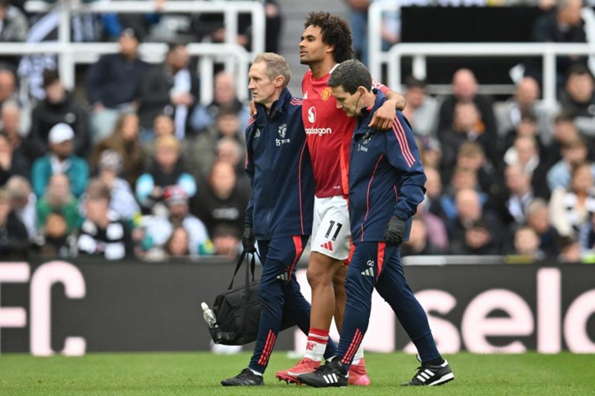 Manchester United's Dutch striker #11 Joshua Zirkzee is helped off the pitch after picking up an injury during the English Premier League football match between Newcastle United and Manchester United at St James' Park in Newcastle-upon-Tyne, north east England on April 13, 2025. ANDY BUCHANAN / AFP