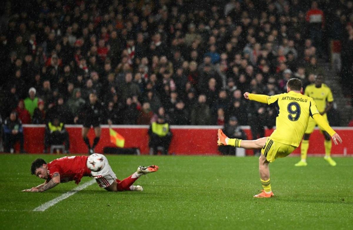 Fenerbahce's Turkish striker #09 Muhammed Kerem Akturkoglu shoots past Nottingham Forest's Welsh defender #03 Neco Williams to score the opening goal during the UEFA Europa League Knockout Round Play-off second-leg football match between Nottingham Forest and Fenerbahce SK at The City Ground in Nottingham, central England, on February 26, 2026. Oli SCARFF / AFP